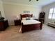 Cozy bedroom features a dark wood bed set, neutral walls, and plenty of natural light at 3962 Kennebunk Loop, Mount Dora, FL 32757