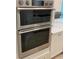 Close-up of stainless steel oven with modern design and sleek finish, kitchen in background at 3962 Kennebunk Loop, Mount Dora, FL 32757