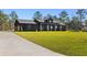 Dark-sided modern farmhouse with metal roof and large grassy yard at 7699 Sw 140Th Ave, Dunnellon, FL 34432