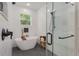 Bright bathroom features a modern tub, glass shower, and black fixtures against white tile at 12365 Sw 54Th Lane Rd, Ocala, FL 34481