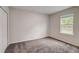 Simple bedroom with grey carpet and a window at 1445 General Mac Arthur Ave, Daytona Beach, FL 32114