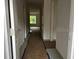 Hallway with view to the outdoors; shows construction progress on the flooring, walls, and door frames at 1445 General Mac Arthur Ave, Daytona Beach, FL 32114