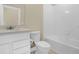The bathroom is well lit and includes a large mirror, white cabinets, a toilet and a shower-tub combo at 7367 Catania Loop, Clermont, FL 34714