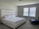 This bedroom features a white bed set, a white headboard and two windows for natural light at 7367 Catania Loop, Clermont, FL 34714