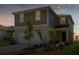 Two-story house with gray siding, two-car garage, and landscaping at 7367 Catania Loop, Clermont, FL 34714