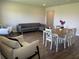 Open concept living area with a couch, dining table, and chairs on wood-look floors at 7367 Catania Loop, Clermont, FL 34714