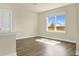 The living room features wood floors and a large window with a view of trees and clouds in the sky at 7367 Catania Loop, Clermont, FL 34714