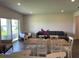 Open-concept living and dining area with sliding glass doors and stylish, neutral decor at 7367 Catania Loop, Clermont, FL 34714