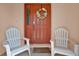 Inviting front entrance with orange door and white chairs at 4223 Arlington Ridge Blvd, Leesburg, FL 34748
