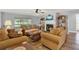 Comfortable living room featuring a fireplace, ceiling fan and access to screened lanai at 4223 Arlington Ridge Blvd, Leesburg, FL 34748