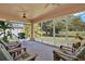 Relaxing sunroom with screened windows, comfortable seating, and views of the lush backyard at 4223 Arlington Ridge Blvd, Leesburg, FL 34748