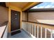 Apartment front porch with wood railing, dark brown door and tan siding at 478 N Pin Oak Pl # 308, Longwood, FL 32779