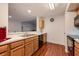A kitchen with wood cabinets and wood floors shows a view of the living room at 478 N Pin Oak Pl # 308, Longwood, FL 32779