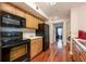 A kitchen with black appliances has wood floors and white countertops at 478 N Pin Oak Pl # 308, Longwood, FL 32779