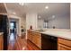 A kitchen with wood cabinets and wood floors shows a view of the laundry and living room at 478 N Pin Oak Pl # 308, Longwood, FL 32779