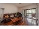 A living room shows a sliding door to a patio, a leather sofa, and wood floors at 478 N Pin Oak Pl # 308, Longwood, FL 32779