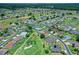 Aerial view of a peaceful residential neighborhood, featuring a golf course, mature trees, and manicured lawns at 2172 Nw 50Th Cir, Ocala, FL 34482
