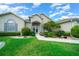 Charming home featuring an arched entryway and lush landscaping with colorful flowerbeds at 2172 Nw 50Th Cir, Ocala, FL 34482