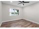 Simple bedroom features a large window with a water view and wood-look flooring at 4790 Anderson Rd, Orlando, FL 32812