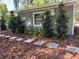 Refreshed home exterior with a modern gray paint, stepping stones, and beautiful manicured landscaping at 4790 Anderson Rd, Orlando, FL 32812