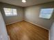 Bedroom featuring wood-look floors and two windows, creating a bright and airy space at 2308 Lake Helen Osteen Rd, Deltona, FL 32738