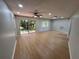 Spacious living room with wood-look flooring, ceiling fan, and sliding glass doors to the outside at 2308 Lake Helen Osteen Rd, Deltona, FL 32738