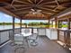 This covered outdoor kitchen has a lakeside view, a ceiling fan, and a dining set at 1911 Lake Markham Preserve Trl, Sanford, FL 32771