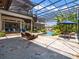 Outdoor pool area surrounded by lush greenery and a screened enclosure at 1911 Lake Markham Preserve Trl, Sanford, FL 32771