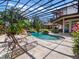Screened-in pool featuring stone accents, a rock waterfall, and landscaped surroundings at 1911 Lake Markham Preserve Trl, Sanford, FL 32771