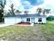 Freshly painted house exhibits neat landscaping with mulched garden beds, complemented by a concrete driveway and a front-facing garage at 2 Fisher Lane Way, Ocklawaha, FL 32179