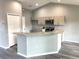 Bright kitchen showcases granite countertops, a breakfast bar with seating, stainless steel appliances, and wood-style flooring at 2 Fisher Lane Way, Ocklawaha, FL 32179