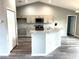 Open kitchen features granite countertops, stainless steel appliances, and an island bar with modern cabinetry and wood flooring at 2 Fisher Lane Way, Ocklawaha, FL 32179