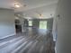 Spacious living area shows an open layout, wood floors, large windows, and easy access to the kitchen at 2 Fisher Lane Way, Ocklawaha, FL 32179