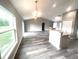 Open concept living area with wood floors adjoining the kitchen has lots of natural light from a large window at 2 Fisher Lane Way, Ocklawaha, FL 32179