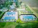 An aerial view showcasing the community's tennis courts, bocce ball, and lush landscaping at 251 Silver Maple Rd, Groveland, FL 34736
