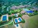 Aerial view of community featuring tennis courts, a pool, community center, and lush landscaping at 251 Silver Maple Rd, Groveland, FL 34736