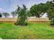 Beautiful backyard featuring a healthy lawn, lush plants, mature trees, and a decorative rock border at 251 Silver Maple Rd, Groveland, FL 34736