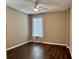 Light-filled bedroom featuring wood floors, a ceiling fan, and a window with curtains at 251 Silver Maple Rd, Groveland, FL 34736
