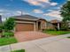 Charming single-story home with a brick driveway, a two-car garage, and stone accents on the entrance at 251 Silver Maple Rd, Groveland, FL 34736