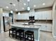 Bright kitchen features a granite island with seating, stainless steel appliances, and ample cabinet space at 251 Silver Maple Rd, Groveland, FL 34736
