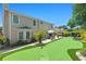 Exterior view of the home’s backyard featuring a putting green, patio with furniture, and a hot tub at 4436 Yachtmans Ct, Orlando, FL 32812