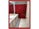 This bathroom has a double sink, white cabinets, and a red shower curtain at 4436 Yachtmans Ct, Orlando, FL 32812