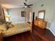 This bedroom features a four-post bed, hardwood floors, two side tables, and a window with blinds at 4436 Yachtmans Ct, Orlando, FL 32812