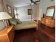 Cozy bedroom with a four-poster bed, wooden nightstands, and a tranquil ambiance at 4436 Yachtmans Ct, Orlando, FL 32812