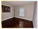 This bedroom has hardwood floors, a tall lamp, a framed picture, a window with blinds, and light-gray walls at 4436 Yachtmans Ct, Orlando, FL 32812