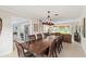 Elegant dining room featuring a large wooden table, stylish chandelier, and an open view to the living room at 4436 Yachtmans Ct, Orlando, FL 32812