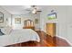 Main bedroom featuring hardwood floors, ceiling fan, and a television at 4436 Yachtmans Ct, Orlando, FL 32812