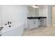 Elegant bathroom with soaking tub, double vanity, and dark countertops at 3018 Avalon Ridge Ln, Winter Garden, FL 34787