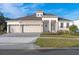 Two-story house with beige walls, stone accents, and a three-car garage at 3018 Avalon Ridge Ln, Winter Garden, FL 34787