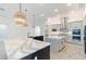 Island kitchen with double sinks, modern pendant lighting and white cabinets at 3018 Avalon Ridge Ln, Winter Garden, FL 34787